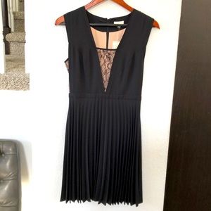 Shoshanna black pleated dress, with beige under lace cutouts.